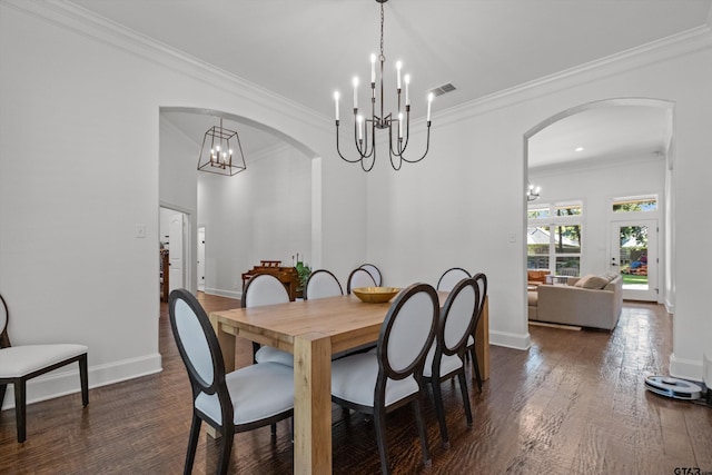 dining room featuring visible vents, a chandelier, ornamental molding, dark wood-style floors, and arched walkways