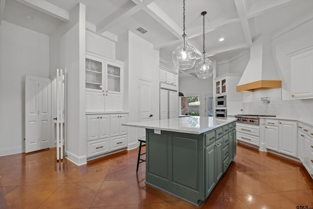 kitchen with visible vents, custom exhaust hood, dark tile patterned flooring, stainless steel appliances, and white cabinetry