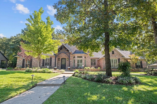 view of front of house featuring a front yard and brick siding