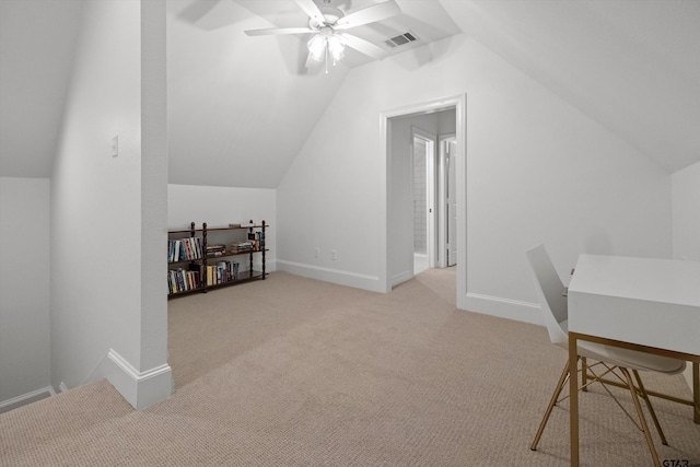 office featuring light carpet, visible vents, a ceiling fan, and vaulted ceiling