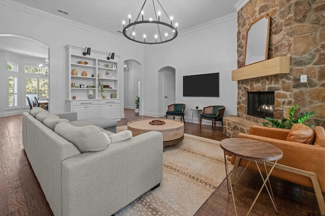 living area featuring a chandelier, ornamental molding, arched walkways, and wood finished floors