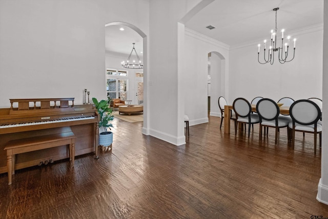 sitting room featuring visible vents, ornamental molding, wood finished floors, arched walkways, and an inviting chandelier