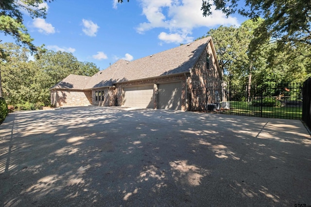 view of front of house with fence, roof with shingles, a garage, aphalt driveway, and brick siding