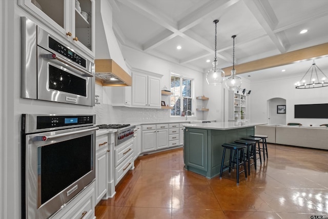 kitchen with white cabinets, tasteful backsplash, appliances with stainless steel finishes, and a center island