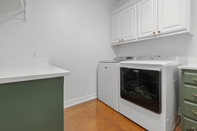 clothes washing area featuring baseboards, cabinet space, separate washer and dryer, and light tile patterned flooring