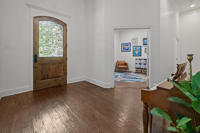 entryway with baseboards, wood finished floors, and ornamental molding