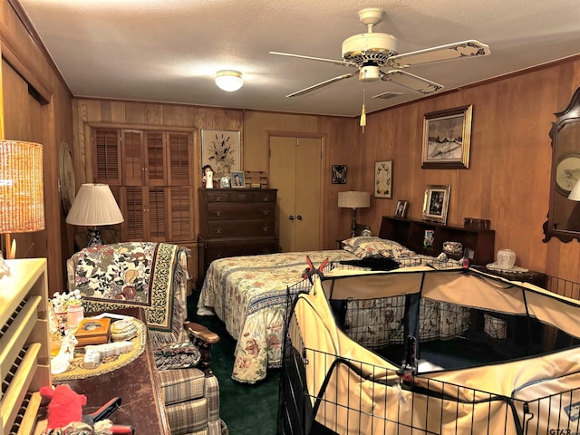 bedroom with wood walls, ceiling fan, and a textured ceiling