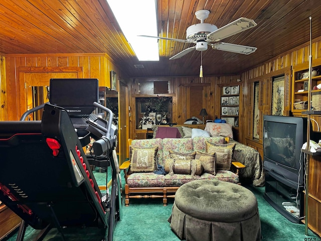 interior space featuring wooden ceiling, ceiling fan, dark colored carpet, and wooden walls