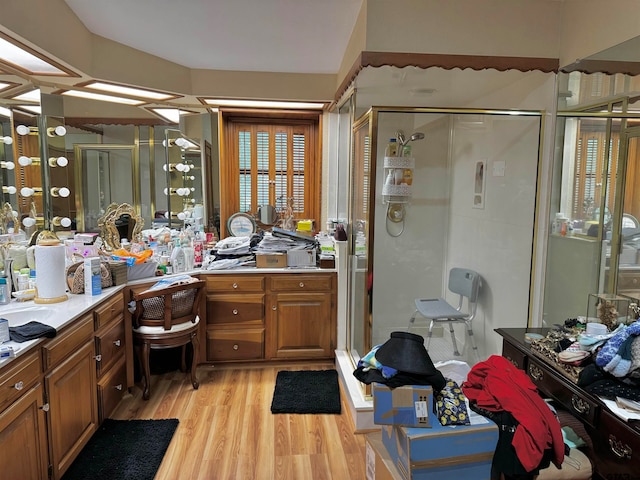 bathroom featuring vanity, hardwood / wood-style flooring, and a shower with door