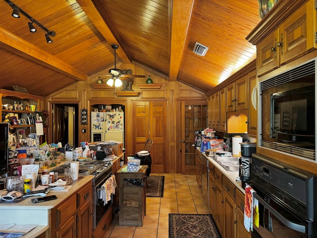 kitchen featuring wooden ceiling, black appliances, light tile patterned floors, wooden walls, and lofted ceiling with beams