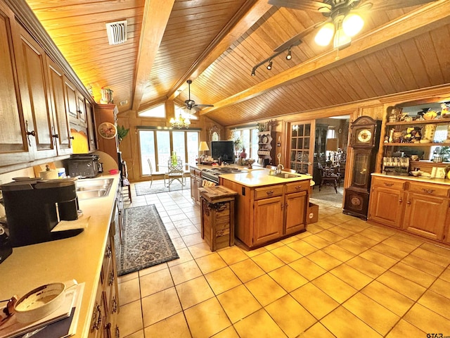 1115 Sunset Ave, Jacksonville, TX 75766 - kitchen featuring a ceiling fan, wood ceiling, light tile patterned floors, light countertops, and brown cabinets