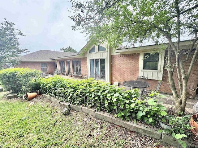 1115 Sunset Ave, Jacksonville, TX 75766 - rear view of property featuring brick siding and board and batten siding