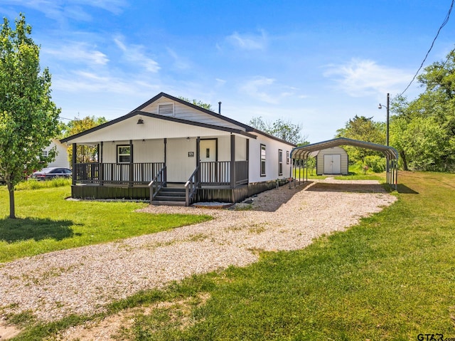 924 Kaufman St, Mount Vernon, TX 75457 - view of front of property featuring a front yard, a carport, covered porch, a storage unit, and driveway