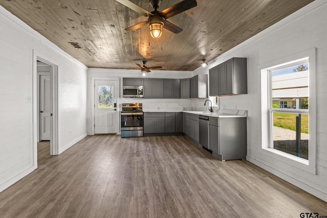 924 Kaufman St, Mount Vernon, TX 75457 - kitchen with wood ceiling, wood finished floors, gray cabinetry, and stainless steel appliances