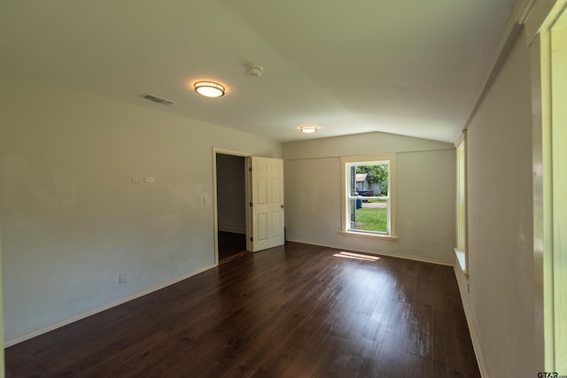 unfurnished room featuring dark wood-type flooring and lofted ceiling