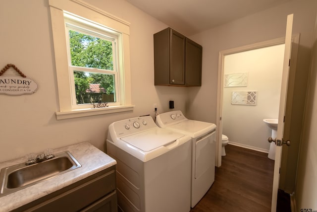 clothes washing area featuring dark hardwood / wood-style floors, sink, and washer and dryer