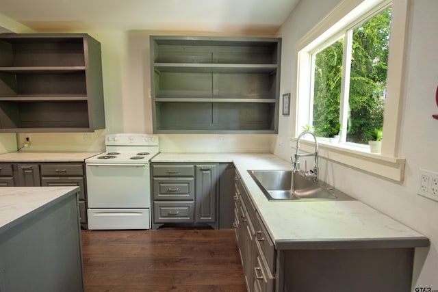 kitchen with white electric range, a healthy amount of sunlight, sink, and dark hardwood / wood-style flooring