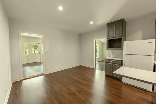 kitchen with gray cabinetry, white fridge, and dark hardwood / wood-style flooring