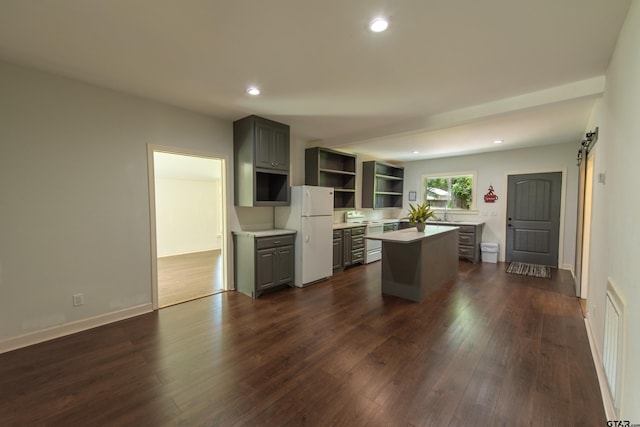 kitchen featuring gray cabinets, dark hardwood / wood-style floors, a center island, and white refrigerator