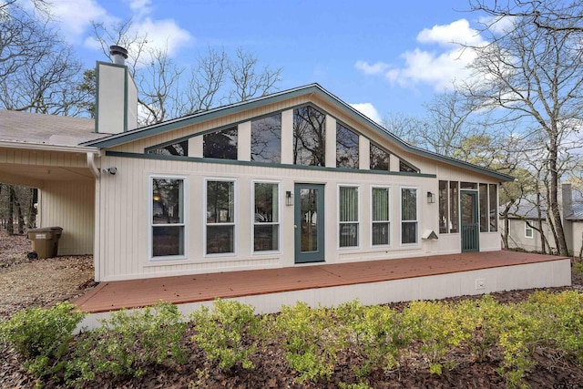 back of house featuring a wooden deck and a sunroom