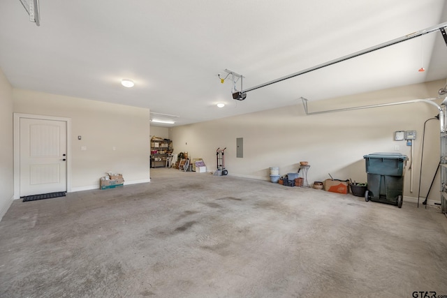 garage featuring baseboards, a garage door opener, and electric panel