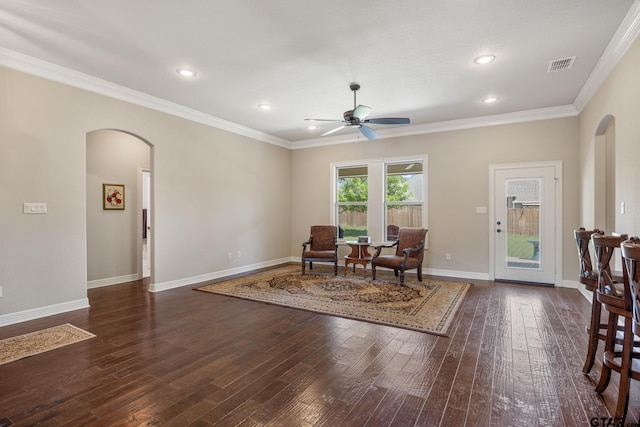sitting room featuring ceiling fan, wood-type flooring, arched walkways, visible vents, and ornamental molding