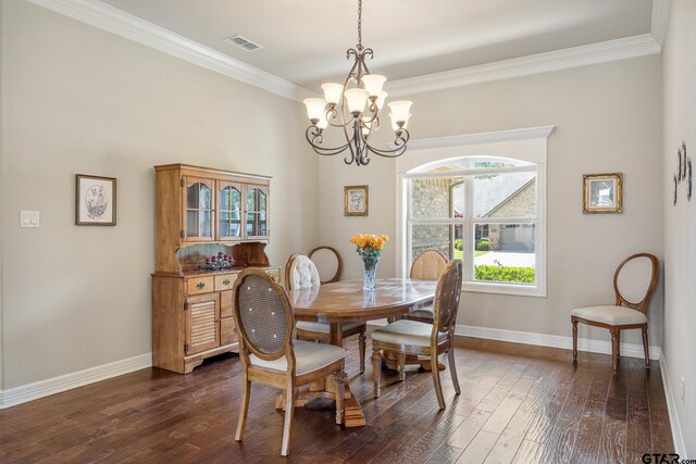 dining room featuring dark wood-style flooring, a chandelier, baseboards, visible vents, and ornamental molding