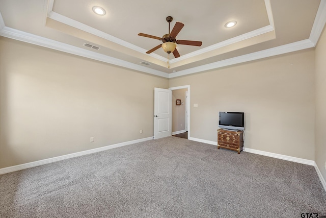 unfurnished room featuring a ceiling fan, visible vents, a raised ceiling, carpet floors, and ornamental molding