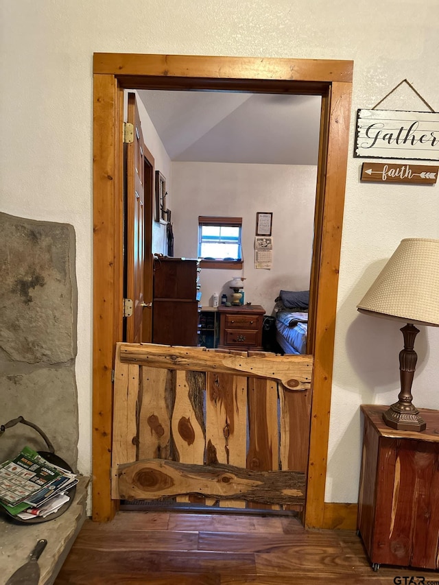 hallway featuring vaulted ceiling and hardwood / wood-style flooring