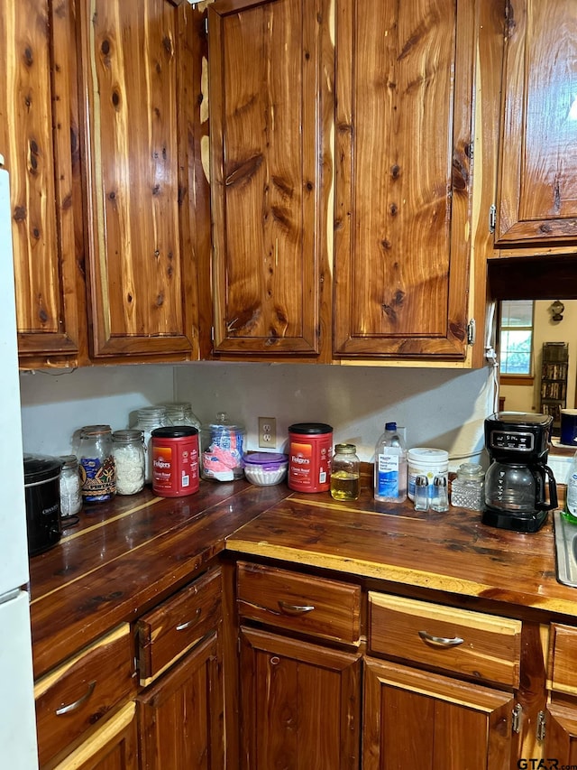 kitchen with wooden counters and white fridge