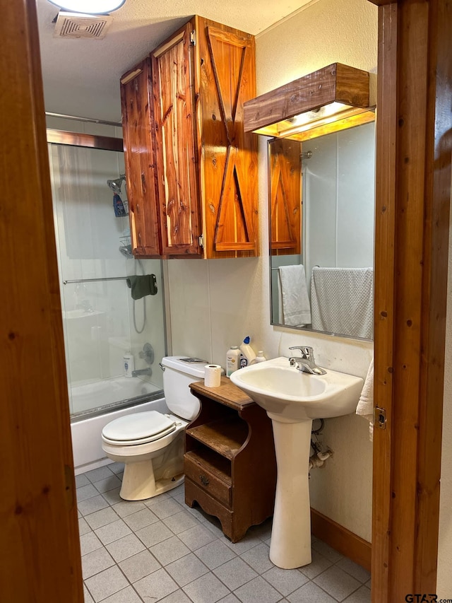 bathroom featuring toilet, tile patterned flooring, and shower / bath combination with glass door