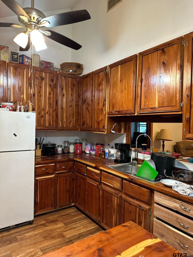 kitchen featuring light hardwood / wood-style flooring, ceiling fan, sink, and white refrigerator