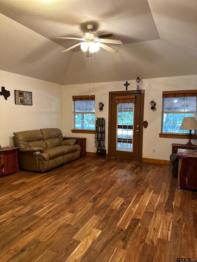 living room with a textured ceiling, dark hardwood / wood-style flooring, ceiling fan, and vaulted ceiling