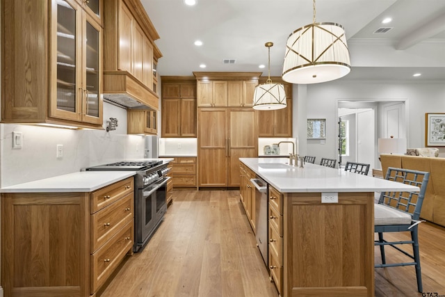 8810 Wilder Trl, Tyler, TX 75703 - kitchen with appliances with stainless steel finishes, a breakfast bar, brown cabinetry, light wood finished floors, and recessed lighting