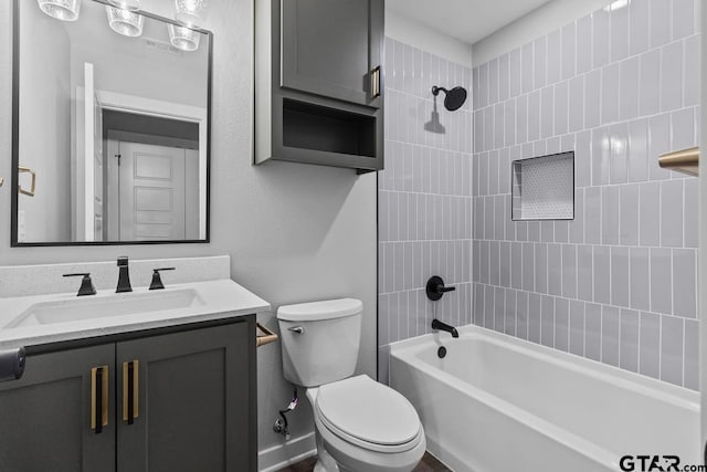 full bathroom featuring vanity, tiled shower / bath combo, and toilet