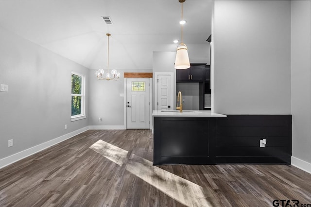 kitchen with sink, vaulted ceiling, dark hardwood / wood-style floors, kitchen peninsula, and a chandelier