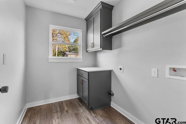 clothes washing area featuring cabinets, washer hookup, hookup for an electric dryer, and dark wood-type flooring