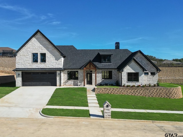 view of front of house with a garage and a front lawn