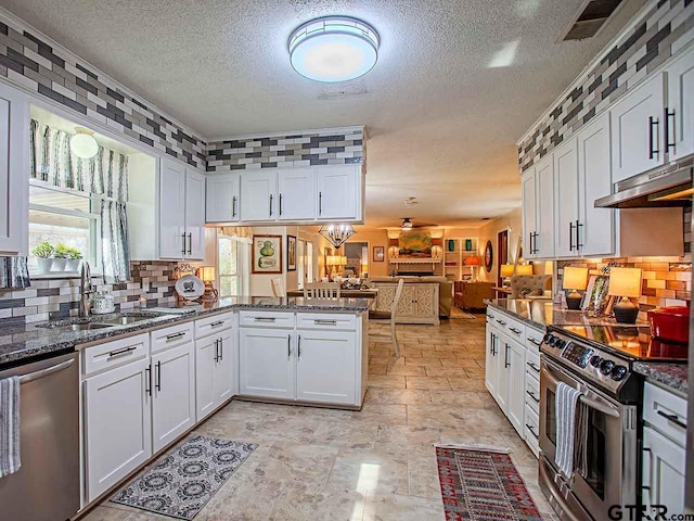 kitchen with stainless steel appliances, white cabinets, sink, and kitchen peninsula