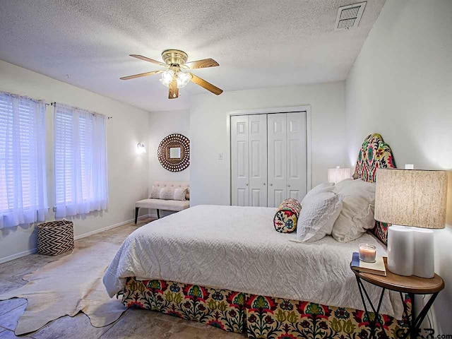 carpeted bedroom featuring a closet, ceiling fan, and a textured ceiling