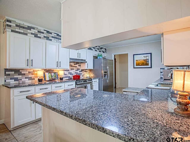 kitchen featuring sink, white cabinets, dark stone countertops, and appliances with stainless steel finishes