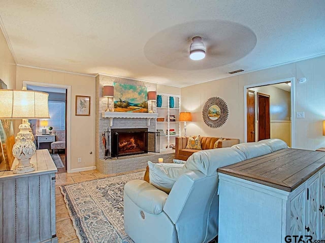 living room with a fireplace, a textured ceiling, ceiling fan, light tile patterned floors, and built in features