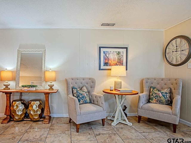 sitting room featuring a textured ceiling and crown molding