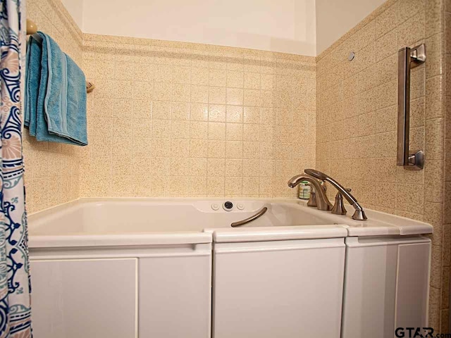 bathroom featuring tile walls and a bathing tub