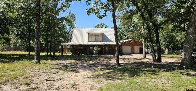7506 Romans Rd, Athens, TX 75751 - view of front of property featuring metal roof, a detached garage, and a porch