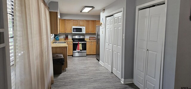 7506 Romans Rd, Athens, TX 75751 - kitchen featuring stainless steel appliances, wood finished floors, light countertops, baseboards, and a sink