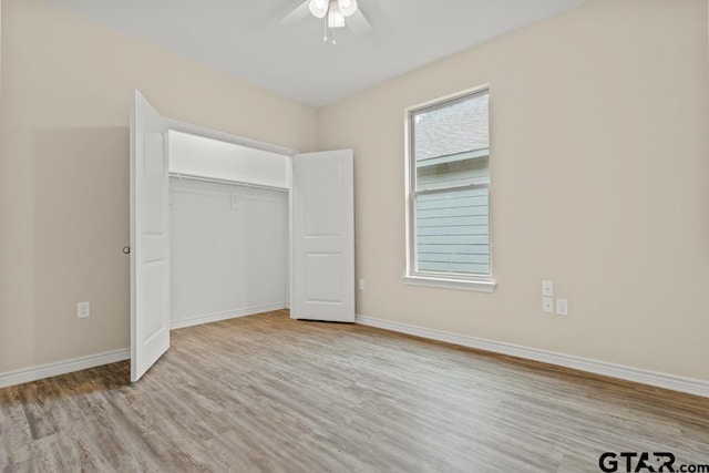 unfurnished bedroom with ceiling fan, a closet, and light wood-type flooring