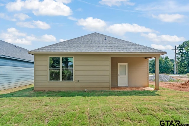 rear view of house featuring a lawn