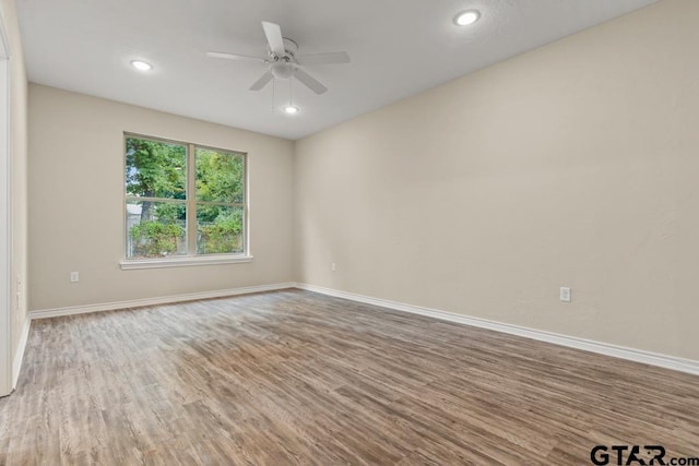 spare room with hardwood / wood-style floors and ceiling fan