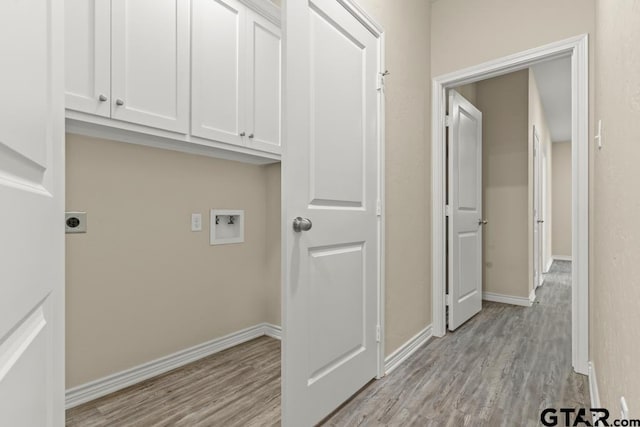 laundry area featuring cabinets, light hardwood / wood-style floors, hookup for a washing machine, and hookup for an electric dryer